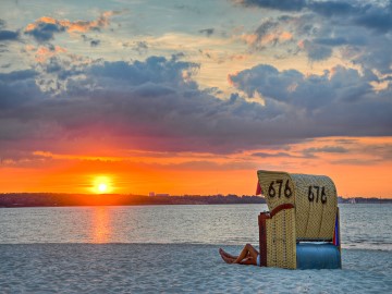 Strand mit Strandkorb an der Ostseeküste im Sonnenuntergang
