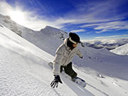 Snowboardfahren bei strahlend blauen Himmel und weißen Pisten.