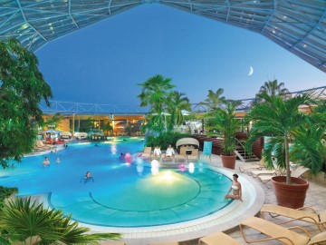 Beleuchtete Freiluft-Therme mit Schwimmbad am Abend