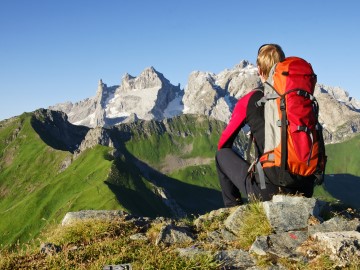 Wanderer auf einem Gipfel mit Blick über die Alpen