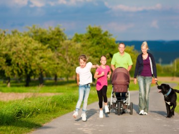 Ferienparks in Deutschland Familie mit Hund beim Spaziergang an einem sonnigen Tag
