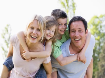 Familienurlaub in der Ferienwohnung Vierköpfige Familie mit fröhlichen Gesichtern